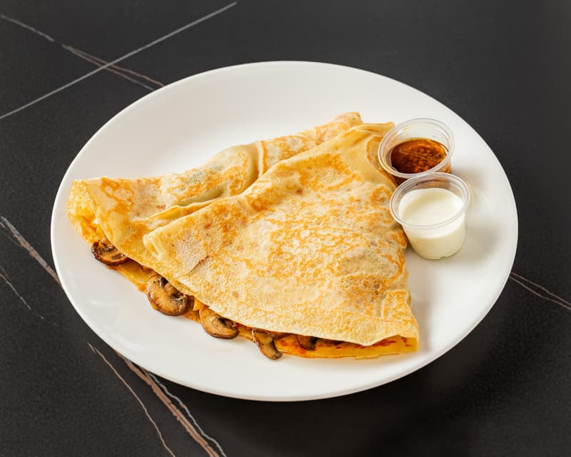 Royal Mushroom Melt crepe with sautéed mushrooms showing at the fold