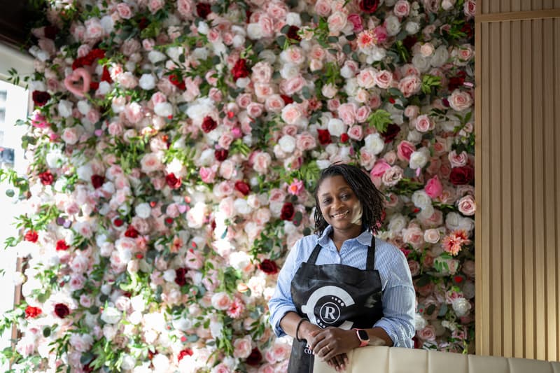Yefon smiling by the rose wall inside the cafe