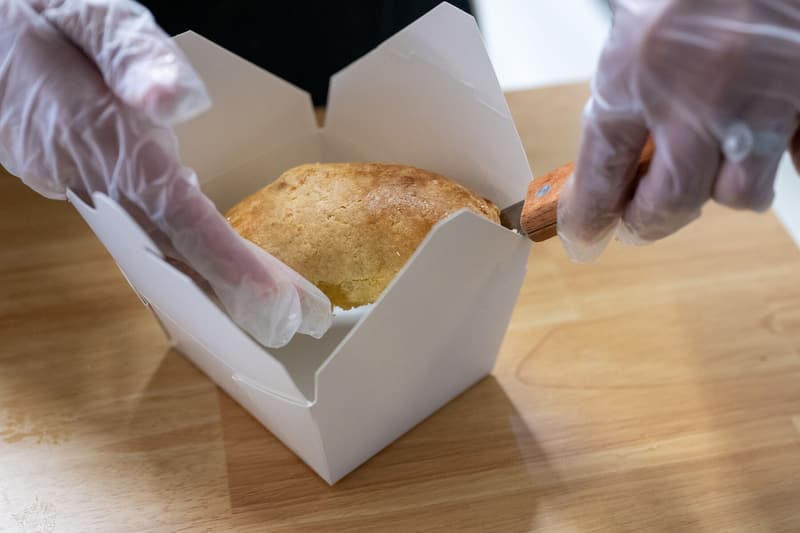 A hand pie going into a to-go box