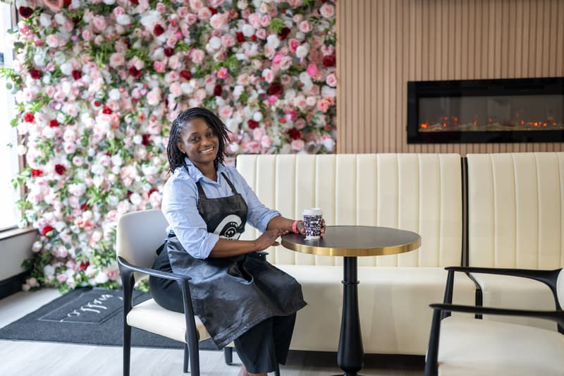 Yefon at a marble-top table by the front window with a 96 Royal cup